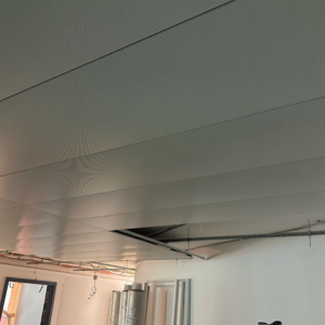 Rénovation en cours avec pose de faux-plafonds métalliques.